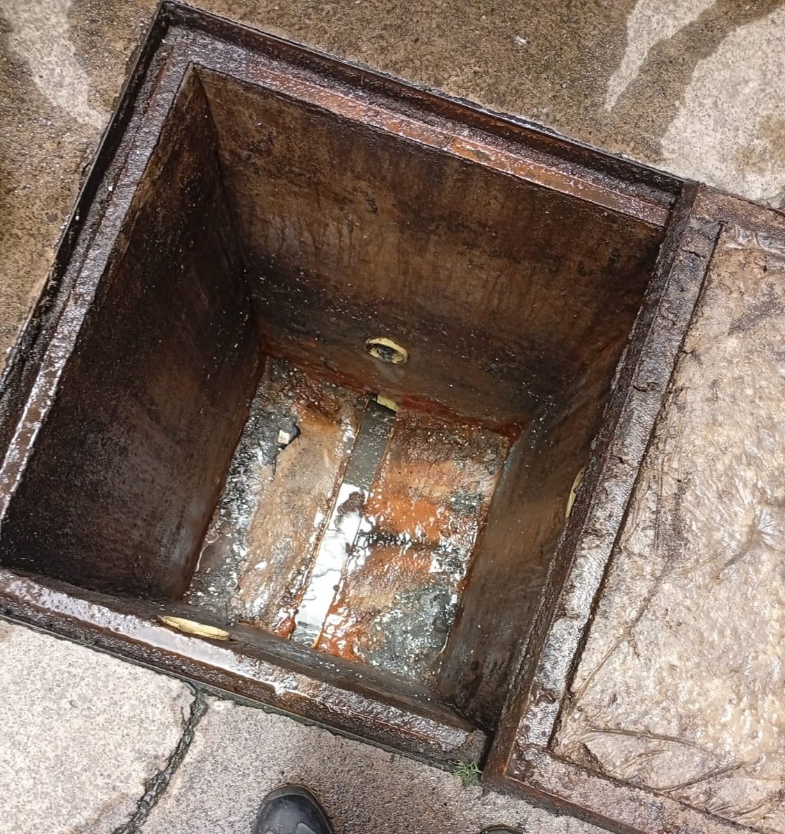 Antes: caja de aguas servidas con lodos y sedimentos en el fondo