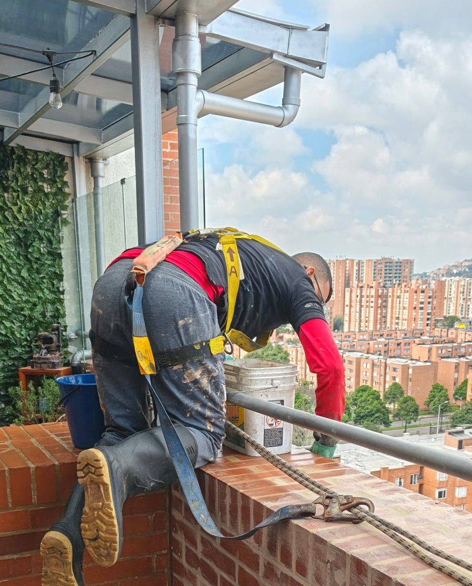 Técnico con arnés trabajando sobre el remate del muro